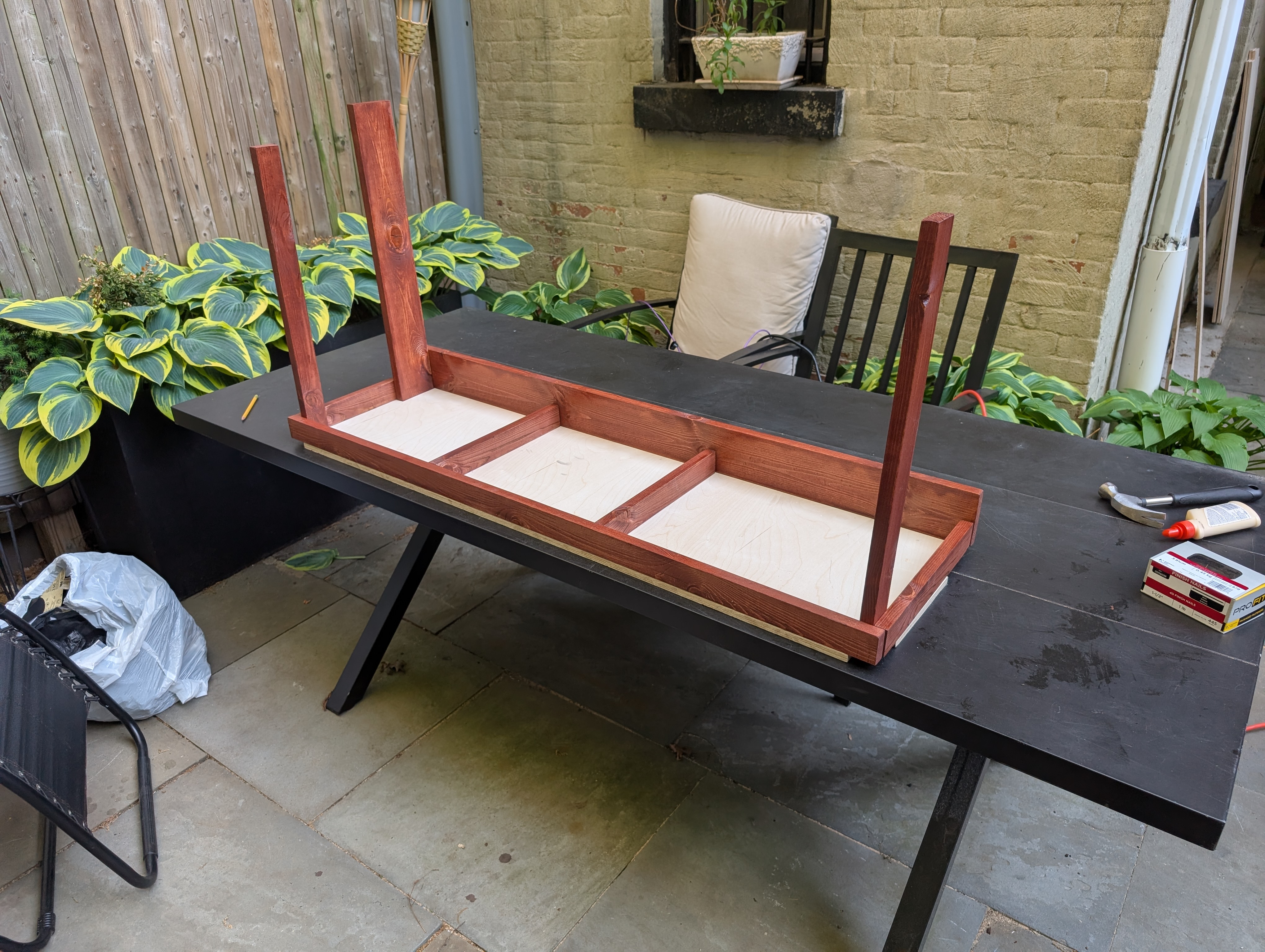 a red frame on white plywood, with vertical boards