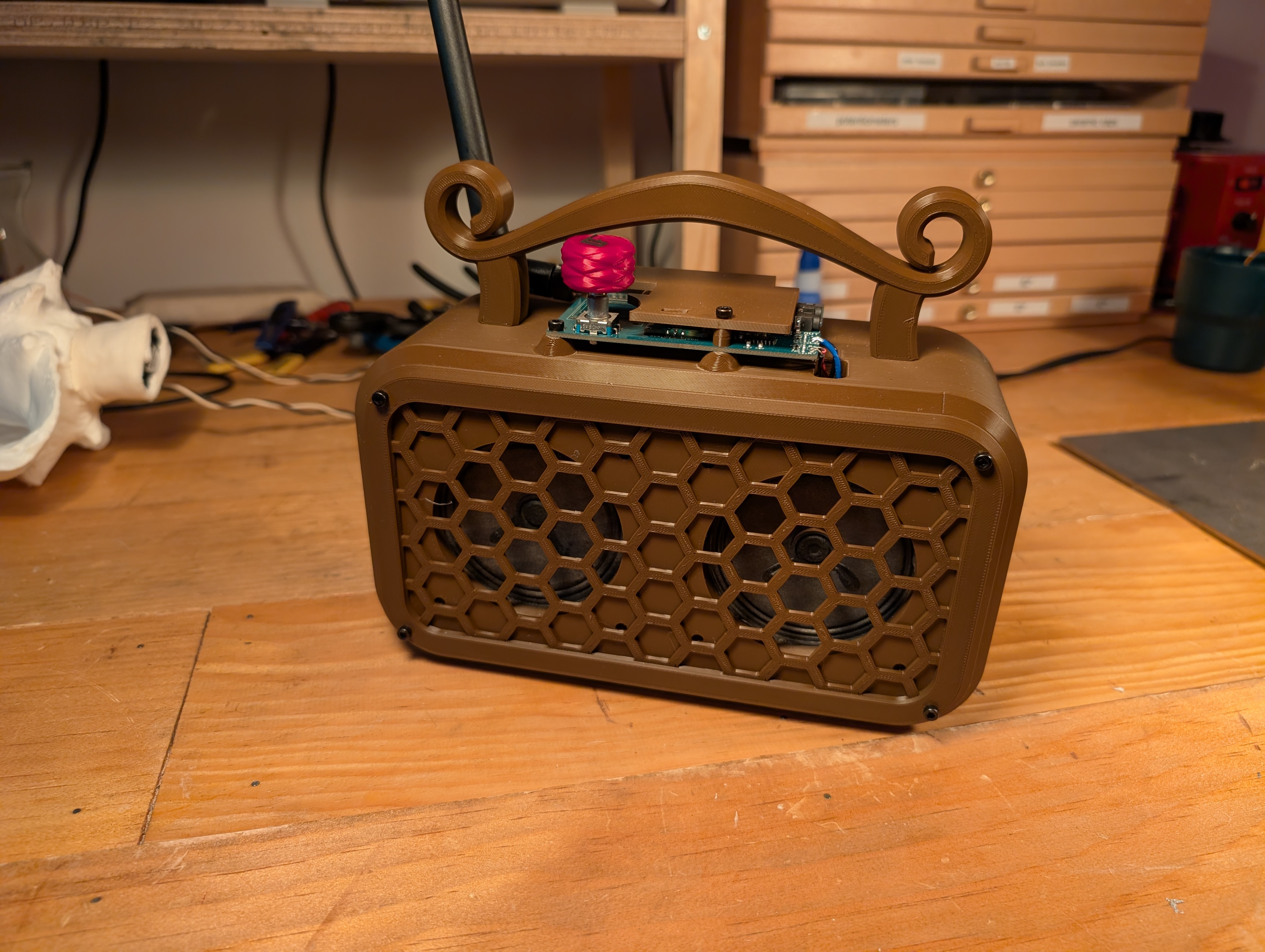 a brown radio with two speakers and a sculpted handle